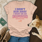 Peach t-shirt with "I Didn't Run Away I Went On An Unsupervised Adventure" text.