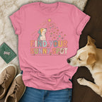 Pink t-shirt with a dog, sun, flowers, paw prints, and text "FIND YOUR SUNNY SPOT."