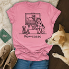 Pink t-shirt with illustration of a bulldog painting a landscape, text "Paw-casso".