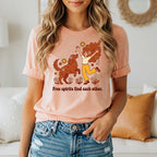 Peach t-shirt with graphic of woman and dog, text "Free spirits find each other."