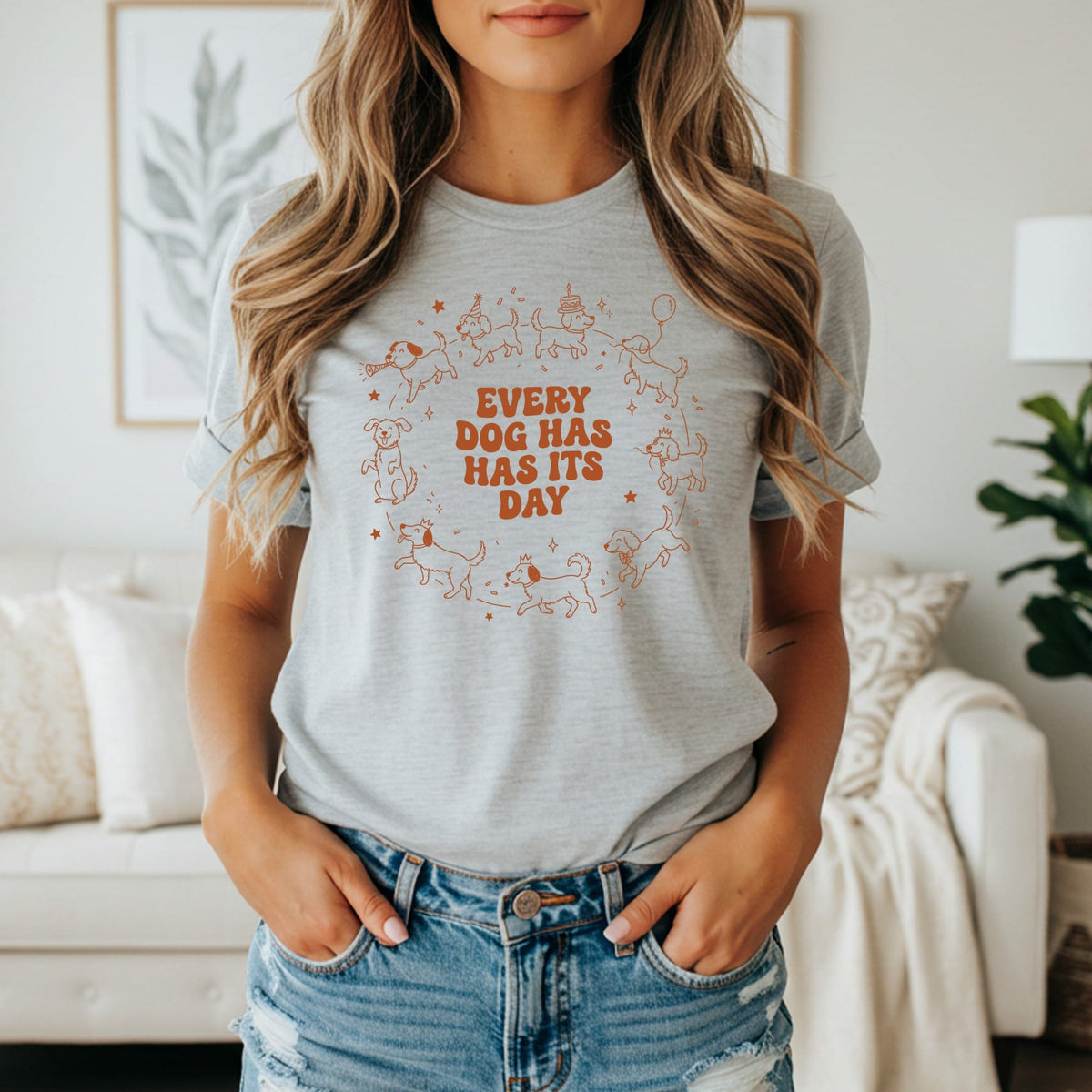 Grey t-shirt with orange "EVERY DOG HAS ITS DAY" text and playful dog illustrations.