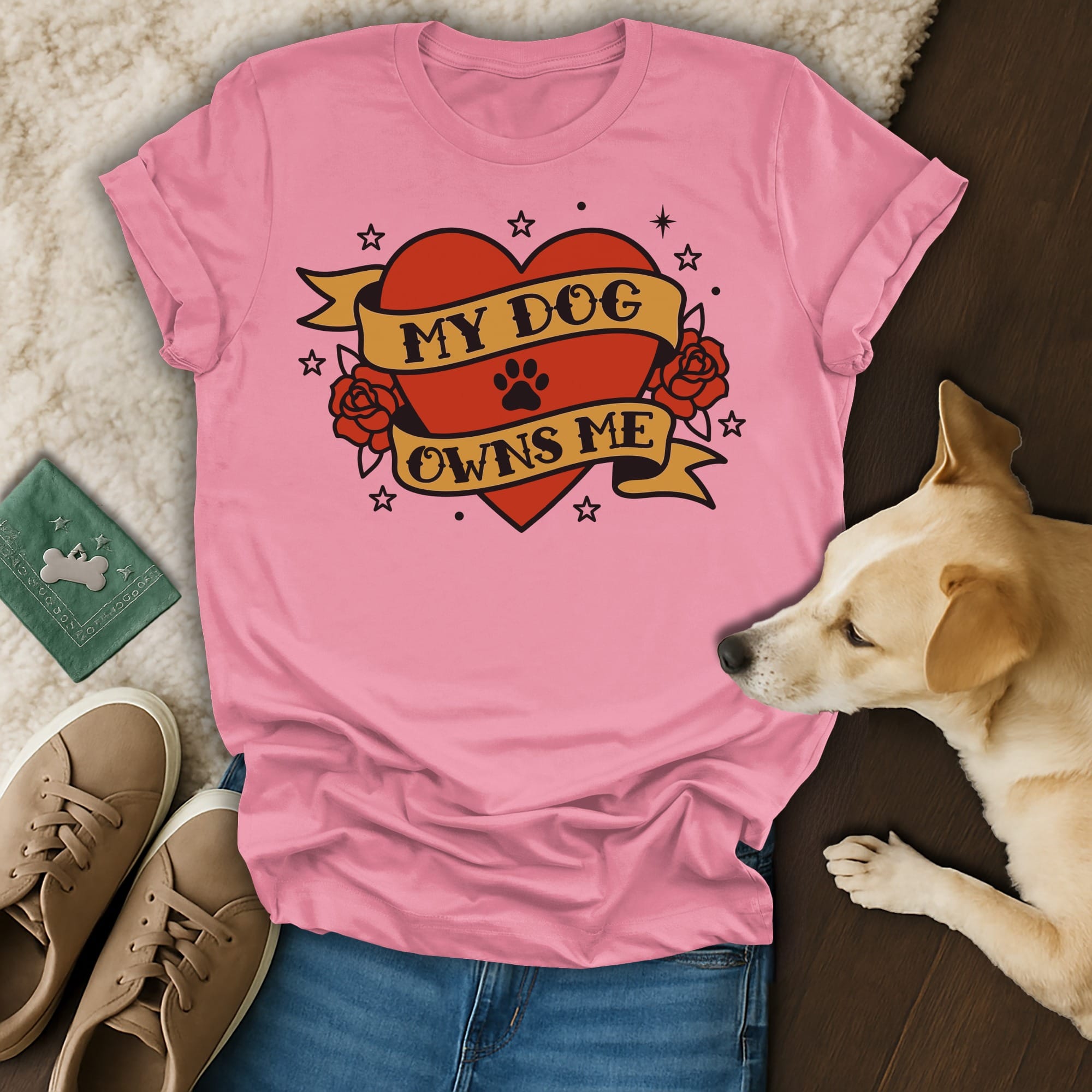 Pink t-shirt with "My Dog Owns Me" heart graphic and dog lying next to it.