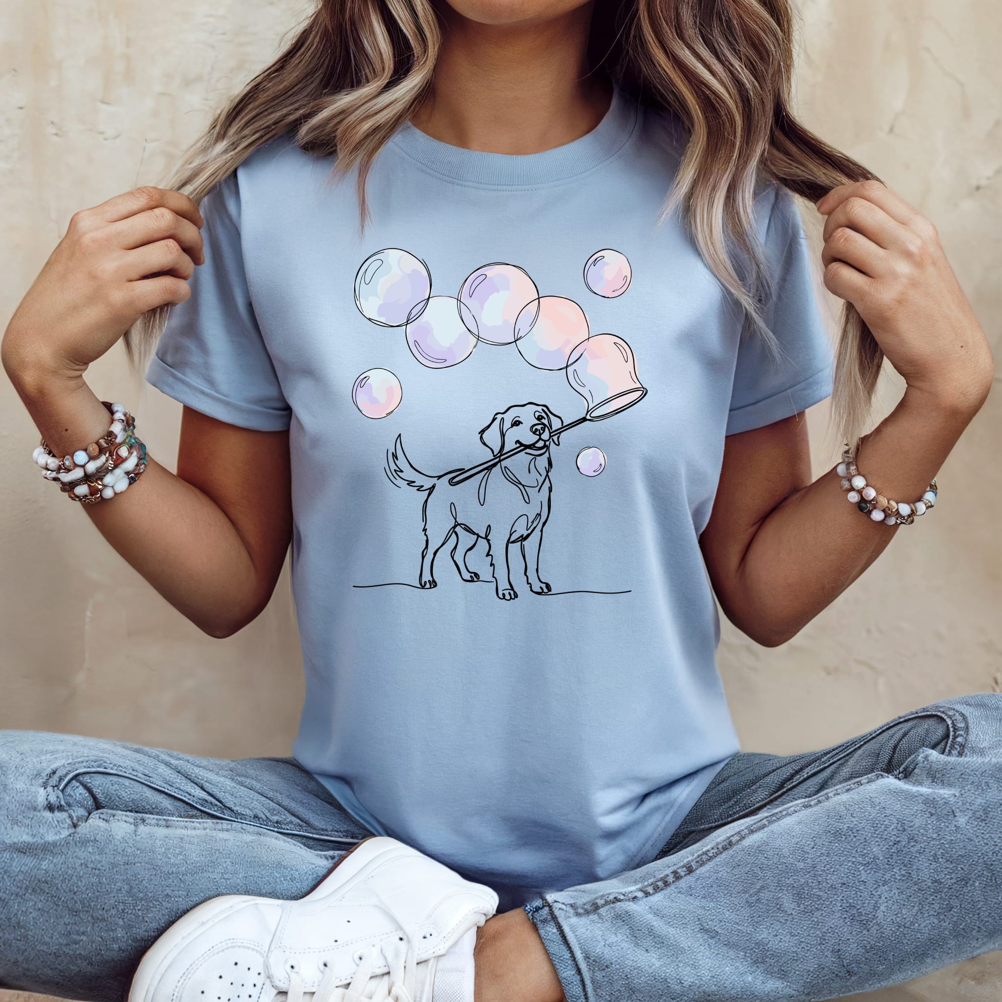 Line art dog blowing bubbles on a light blue t-shirt.