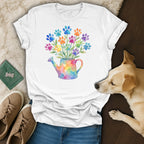 White t-shirt with watercolor paw print flowers in a watering can.