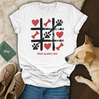 White t-shirt with tic-tac-toe board featuring paw prints, bones, hearts. "Paws Always Win" text.