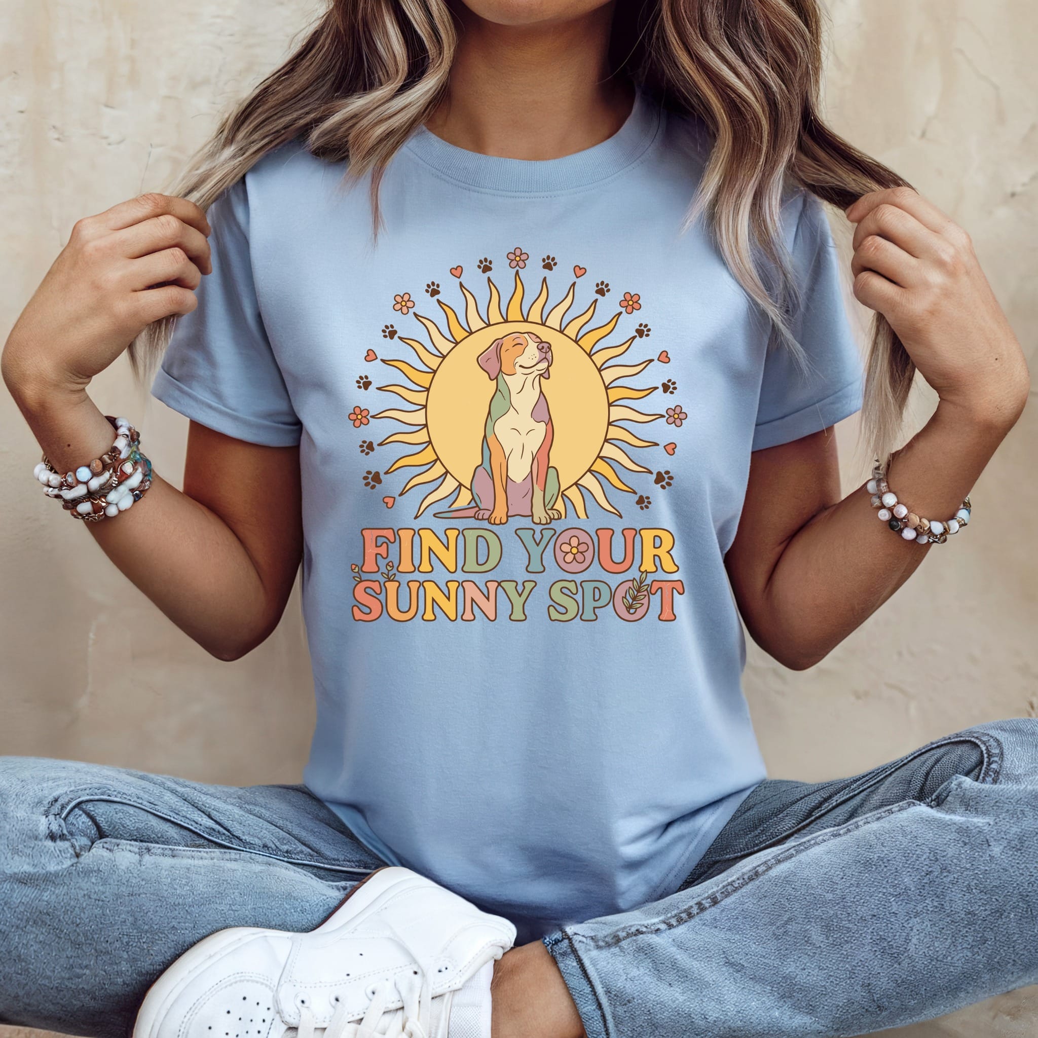 Light blue t-shirt with a dog sitting inside a sun, text reads "FIND YOUR SUNNY SPOT".