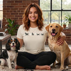 Woman in a shirt with cartoon dogs and ghosts, with two dogs.