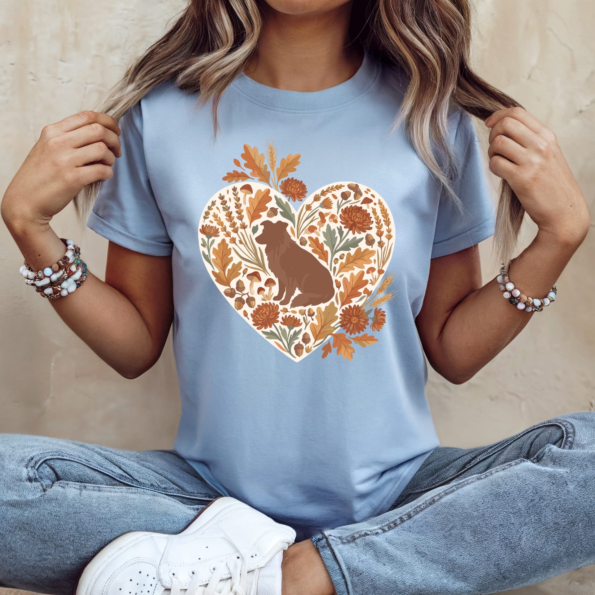 Light blue t-shirt with a heart graphic of a dog, leaves, mushrooms, and acorns.