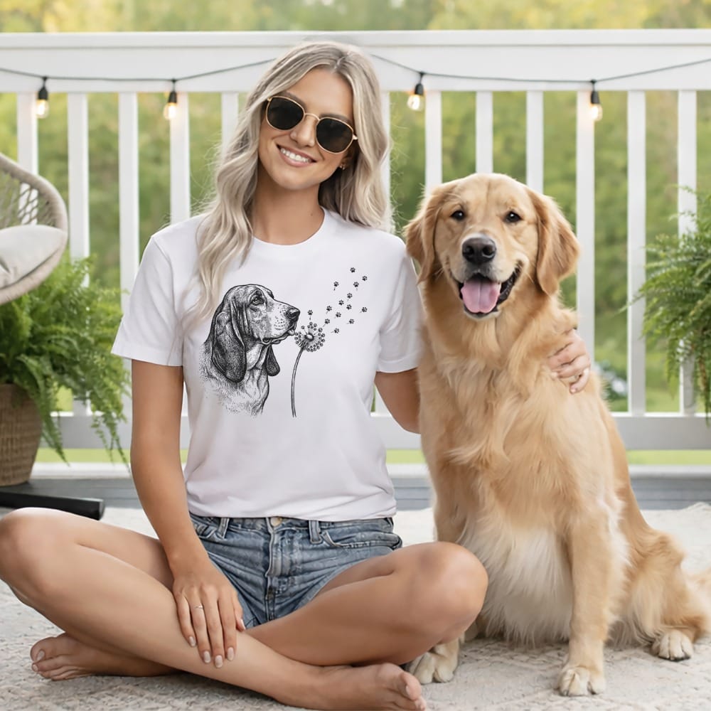 Woman wearing t-shirt with dandelion blowing with dog nearby.