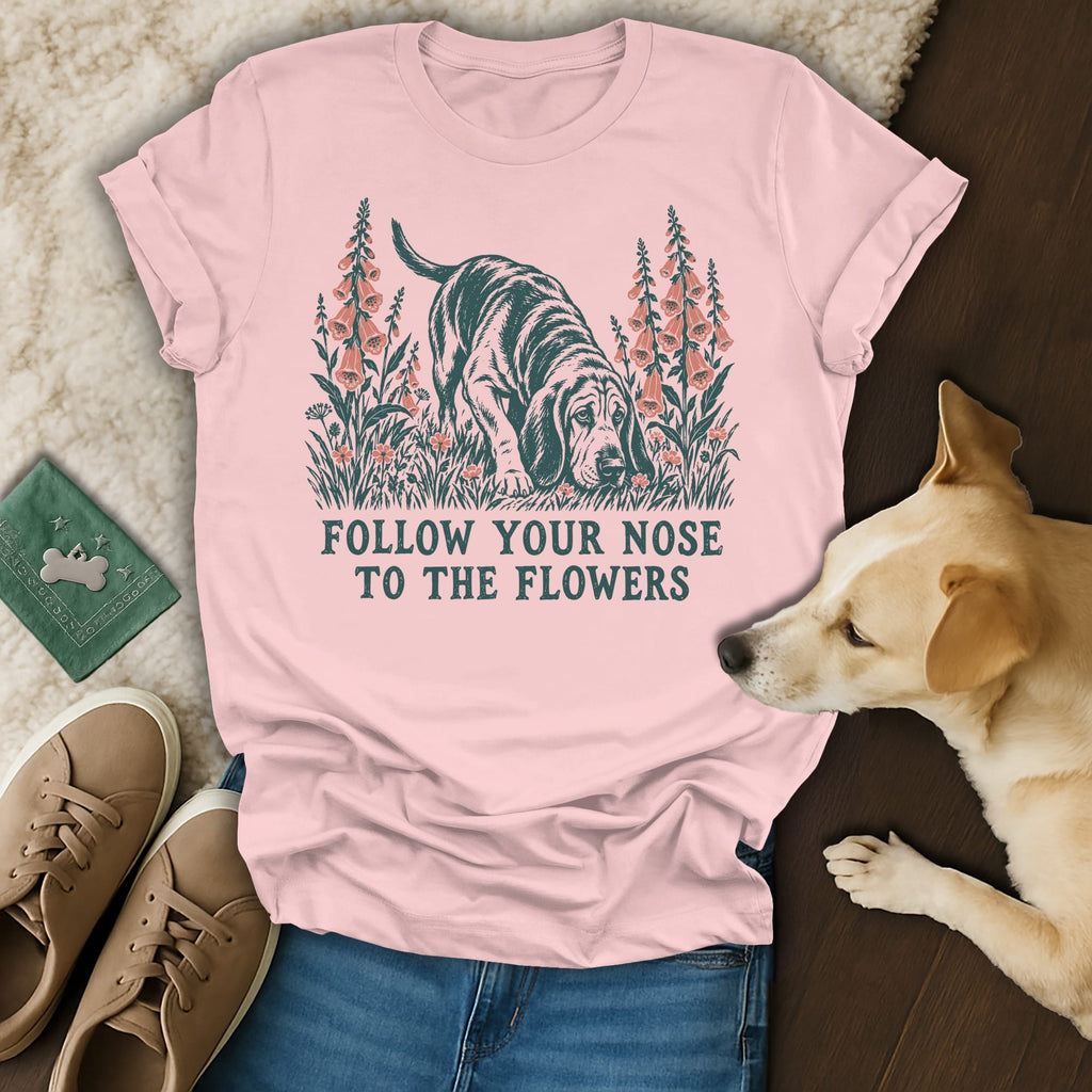 A light pink t-shirt with a graphic of a hound dog and flowers, reading Follow Your Nose to the Flowers.