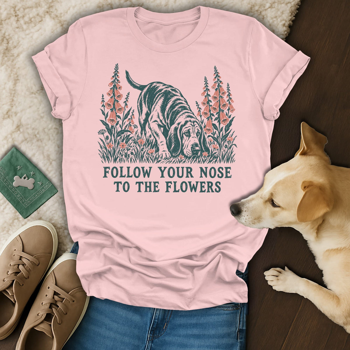 A light pink t-shirt with a graphic of a hound dog and flowers, reading Follow Your Nose to the Flowers.