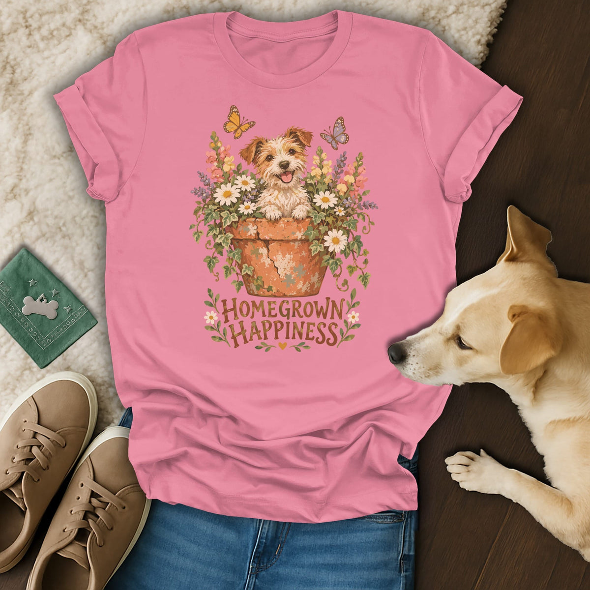 A pink t-shirt featuring a graphic of a puppy in a flowerpot with butterflies and the text Homegrown Happiness.
