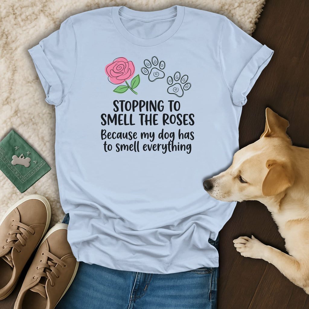 Light blue t-shirt with rose and paw prints, saying "Stopping to smell the roses because my dog has to smell everything".