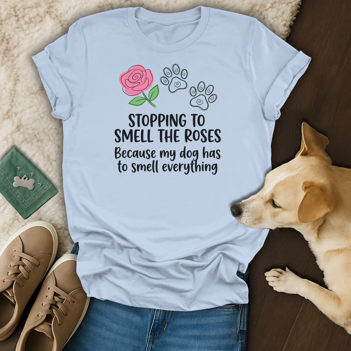 Light blue t-shirt with rose and paw prints, saying "Stopping to smell the roses because my dog has to smell everything".