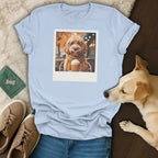 Light blue t-shirt with a dog wearing glasses and scarf holding a drink.