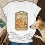 A white v-neck t-shirt displays a vintage seed packet graphic featuring a golden retriever among colorful flowers.