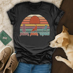 Black t-shirt with "paws, pose, repeat" text and sunset dog yoga graphic.