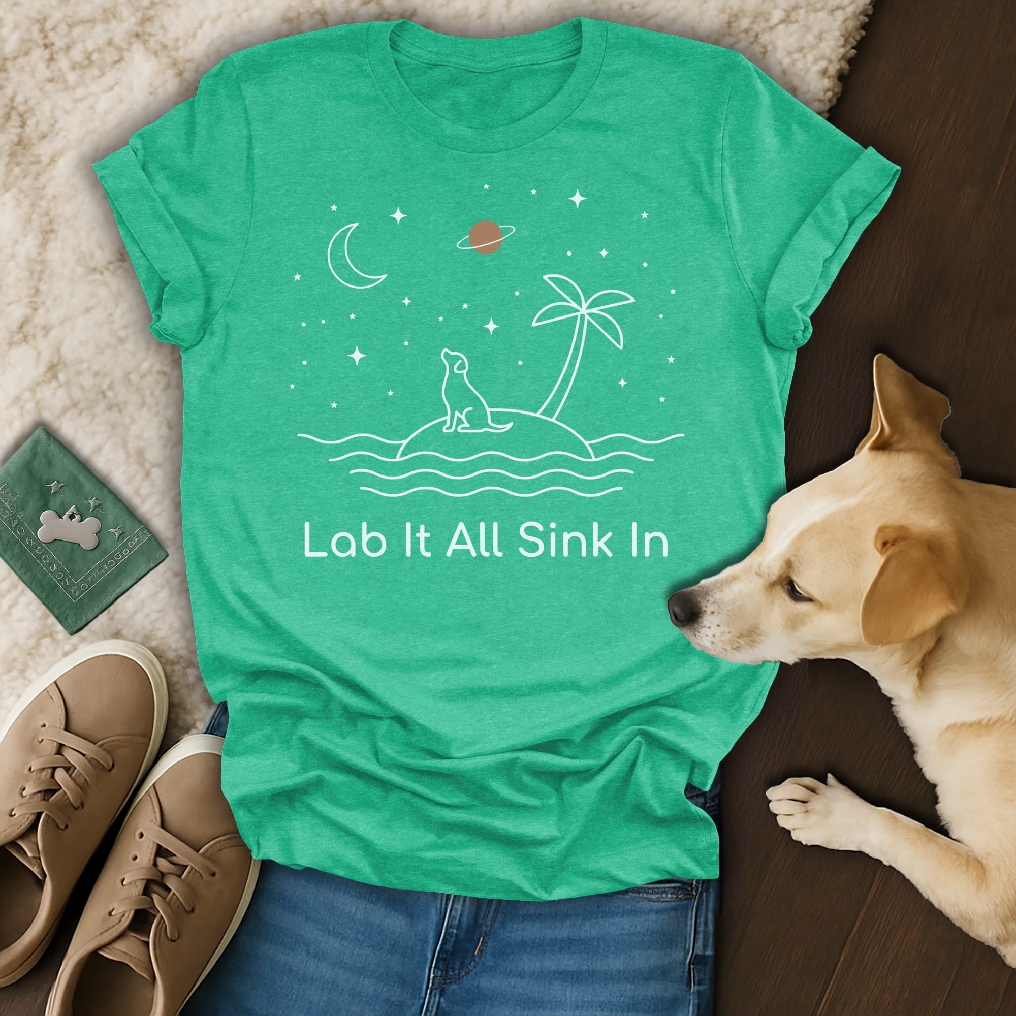 Green t-shirt with white line art of a dog on an island under a starry sky.