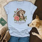 Light blue t-shirt featuring a botanical illustration of an older dog and pink roses with text reading GRAY MUZZLE ROSE.