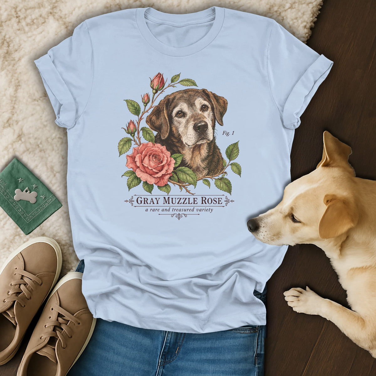 Light blue t-shirt featuring a botanical illustration of an older dog and pink roses with text reading GRAY MUZZLE ROSE.