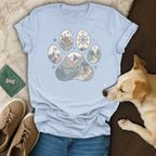 T-shirt with paw print design showing hiking boot, compass, bridge, and mountains.