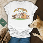 White t-shirt with "Lucky Paws" text and cartoon dogs, next to a dog.