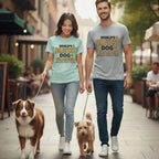 Couple walking two dogs, wearing "World's Okayest Dog Trainer" shirts.