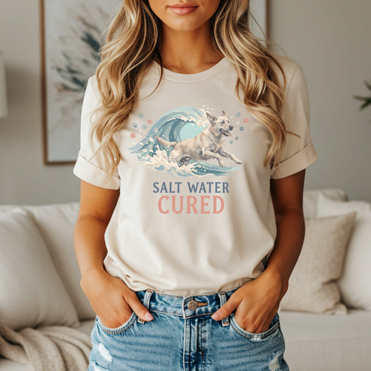Cream t-shirt with graphic of dog running through wave, text reads "Salt Water Cured."
