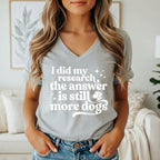 Grey v-neck t-shirt with white text: "I did my research the answer is still more dogs."