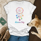 White t-shirt with colorful dreamcatcher and paw prints, "dream big" text.
