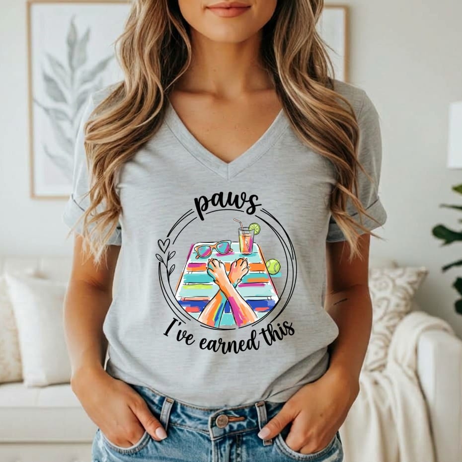 Graphic on t-shirt with dog paws, sunglasses, drink, and "paws I've earned this".