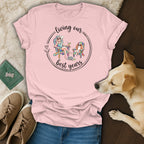 Pink t-shirt with graphic of woman and dog relaxing in chairs, reading "living our best years".