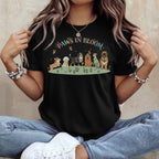Black t-shirt with "Paws in Bloom" and dogs in a field with butterflies.