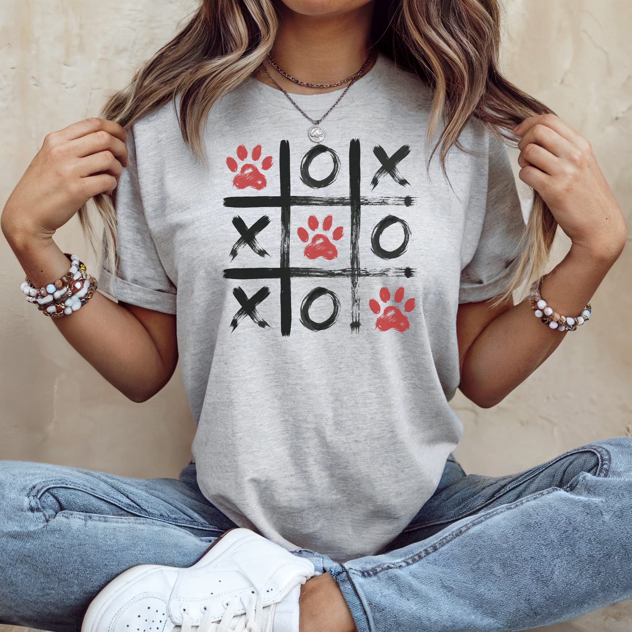 Gray t-shirt with a watercolor tic-tac-toe design featuring red paw prints.
