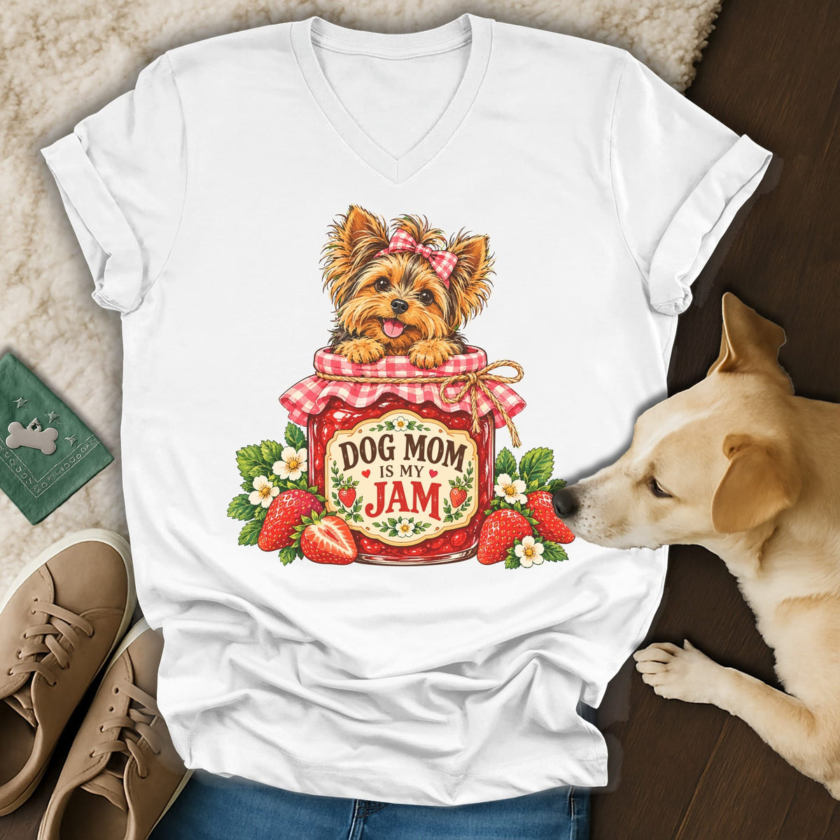 A white v-neck t-shirt featuring a graphic of a Yorkshire terrier inside a strawberry jam jar with the text Dog Mom Is My Jam.