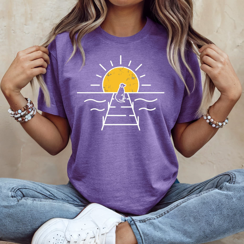 Purple t-shirt with a white graphic of a dog on a pier at sunset.