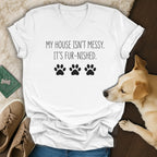 White v-neck t-shirt with "MY HOUSE ISN'T MESSY. IT'S FUR-NISHED." and paw prints.