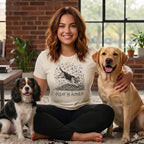 Woman with two dogs, graphic on shirt reads "Leaf Me Alone."