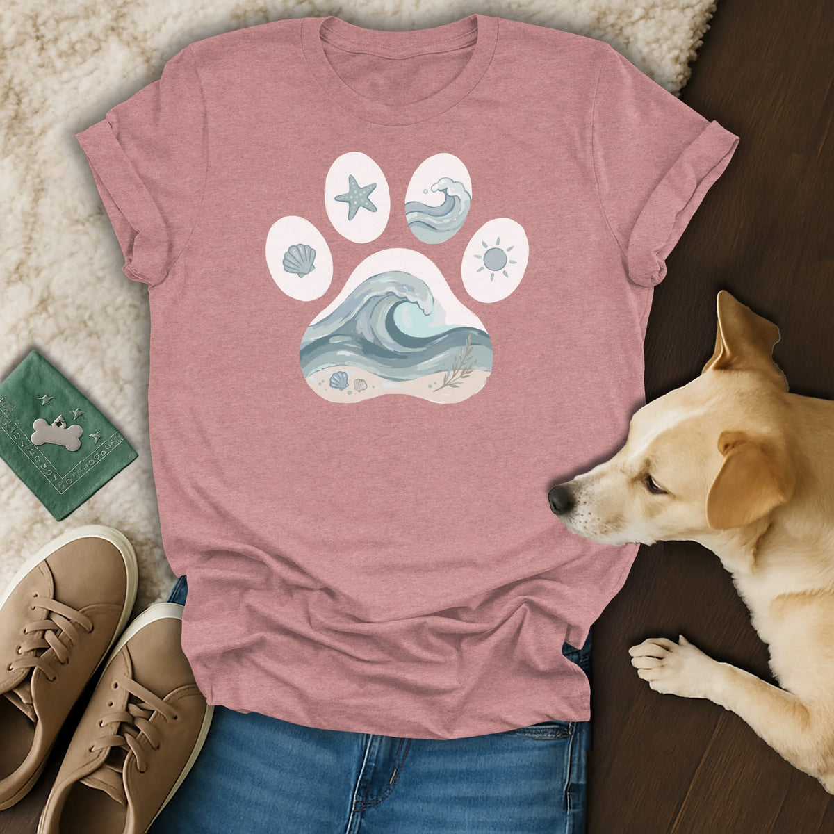 Pink t-shirt with a paw print design featuring ocean wave, starfish, sun, and shell graphics.