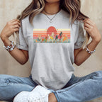 T-shirt with colorful cartoon dogs and sunset graphic.