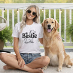 Woman in white "Bestie" t-shirt with golden retriever on a porch.