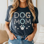 "Dog Mom" text made of seashells and stones, with a paw print and shells below.
