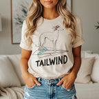 Cream t-shirt with a line drawing of a dog on a paper airplane.