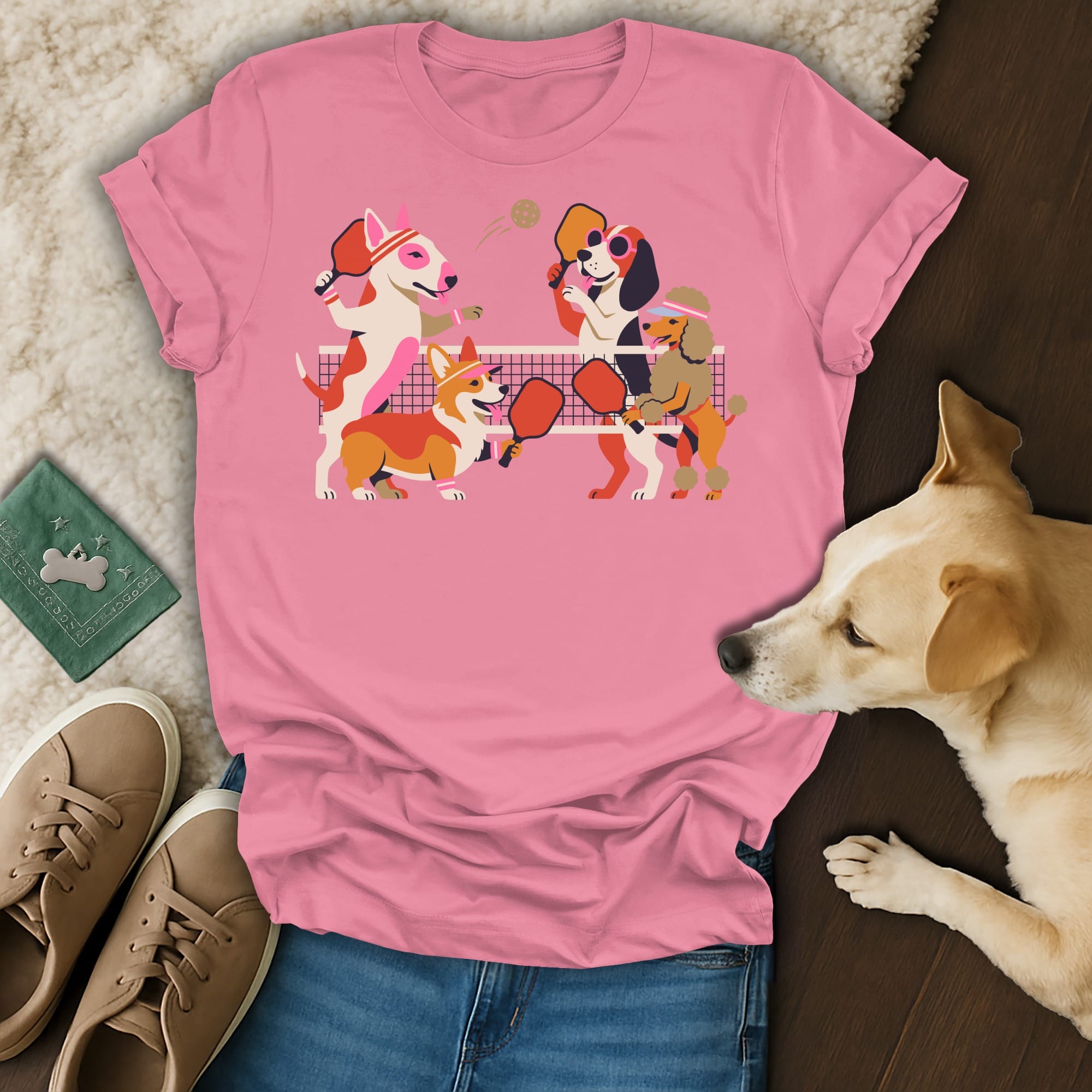 Pink t-shirt with cartoon dogs playing pickleball, a frisbee, and sneakers.