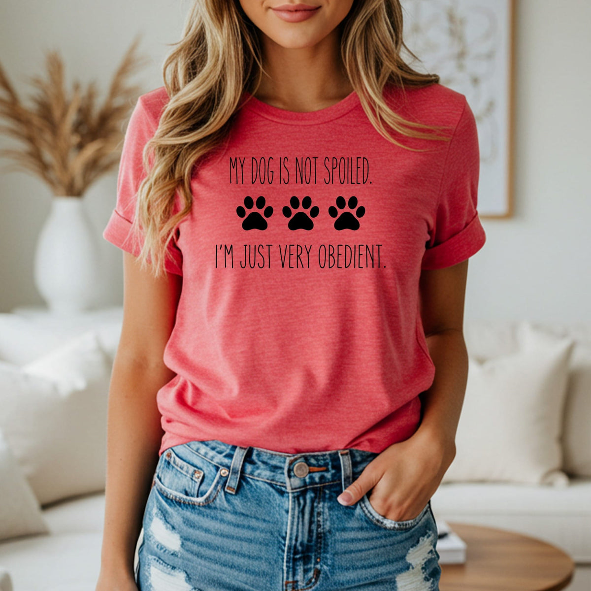 Red t-shirt with black text "MY DOG IS NOT SPOILED. I'M JUST VERY OBEDIENT." and paw prints.
