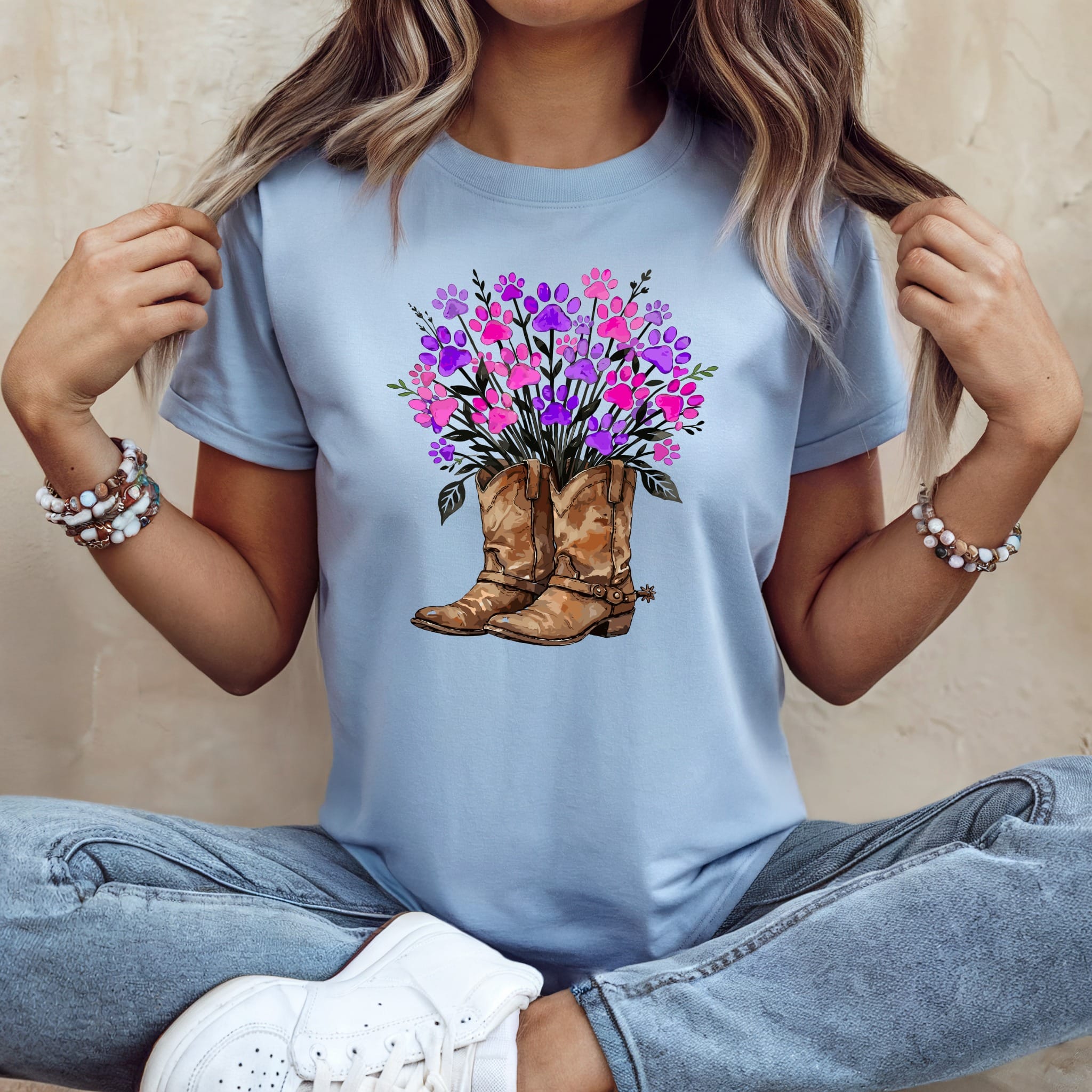 Light blue t-shirt with cowboy boots and colorful paw print floral arrangement.