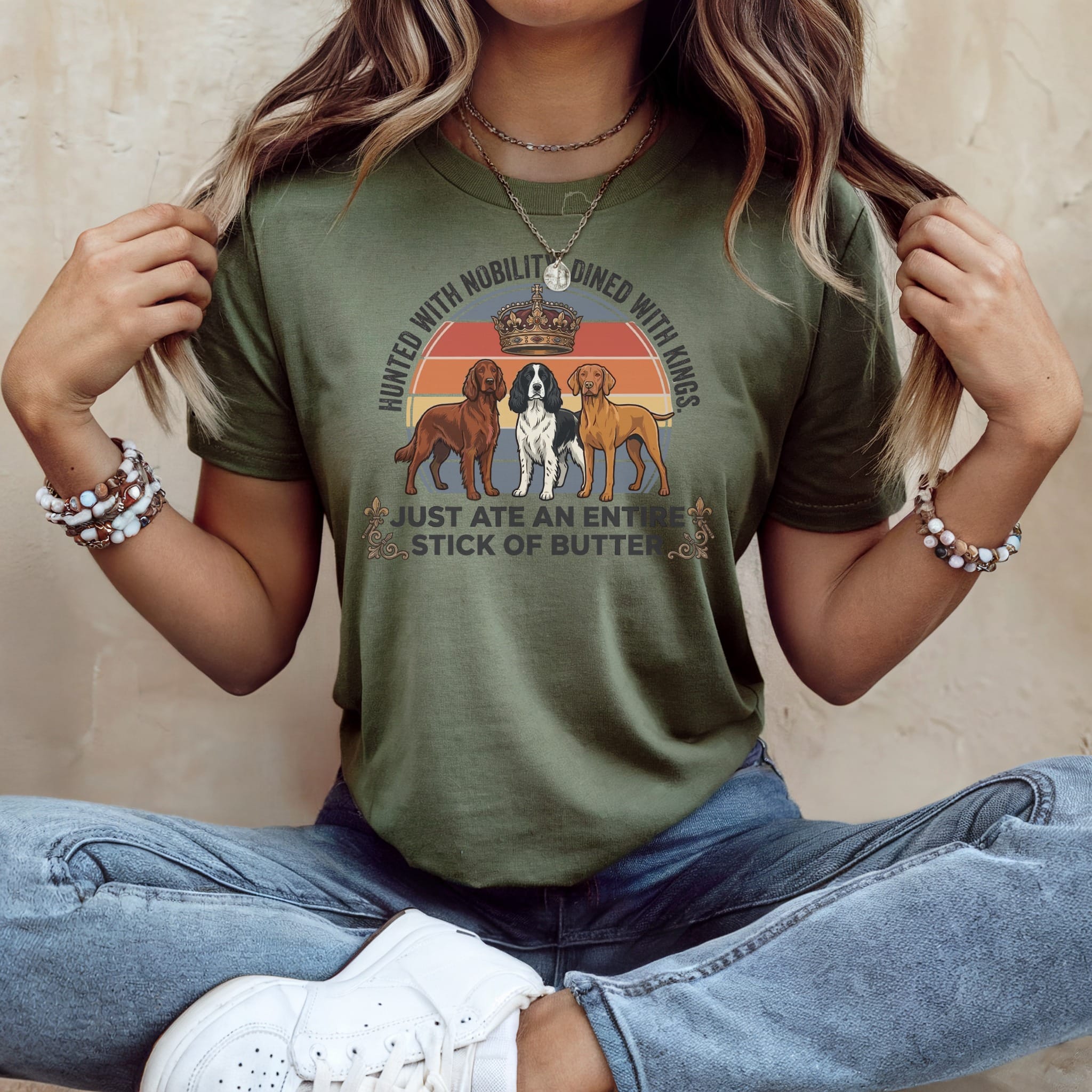 Green t-shirt with three dogs and text "HUNTED WITH NOBILITY DINED WITH KINGS. JUST ATE AN ENTIRE STICK OF BUTTER."
