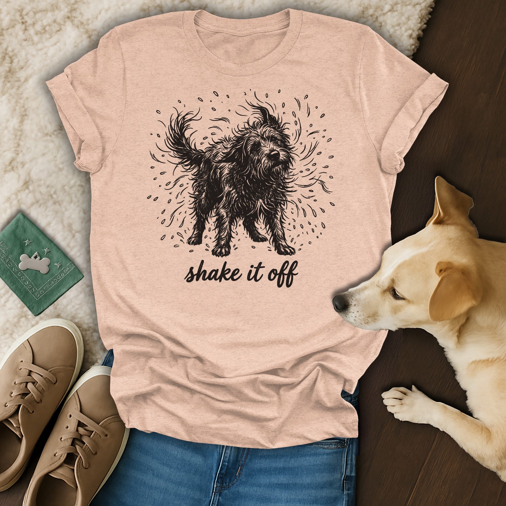 Black shaggy dog illustration with "shake it off" text on a peach t-shirt.
