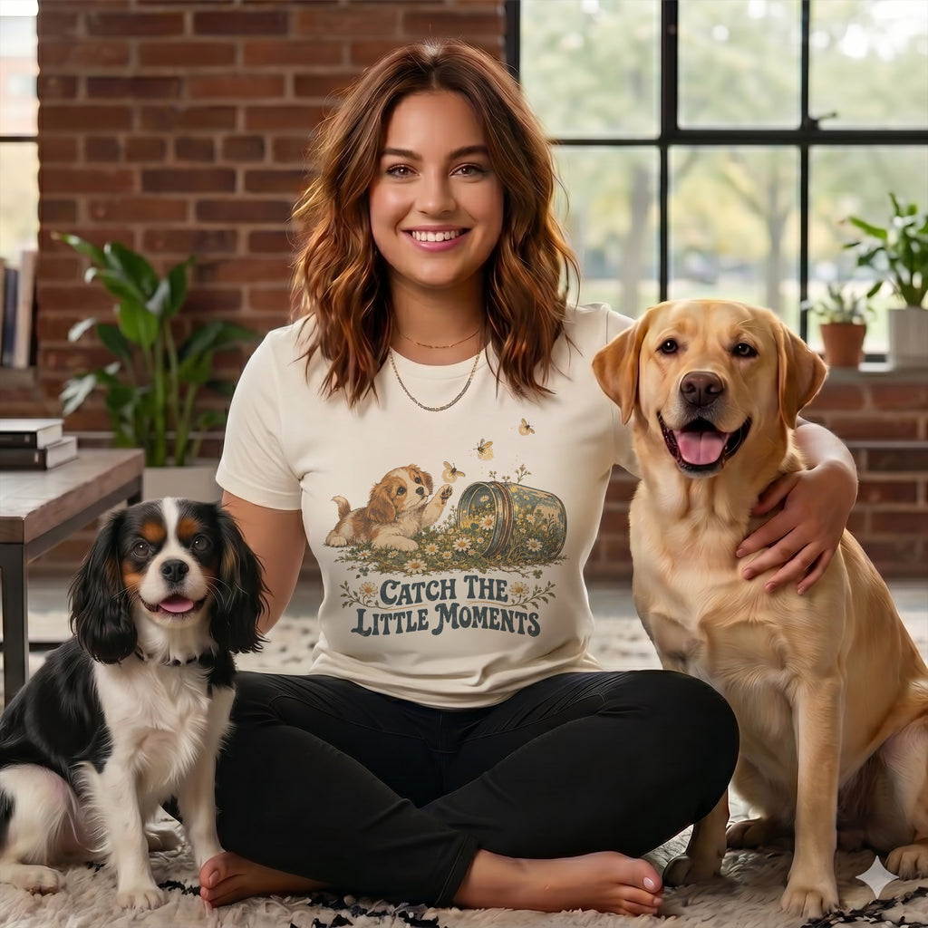 Smiling woman sitting on the floor with a Cavalier King Charles Spaniel and a Labrador Retriever.