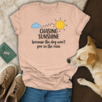 Peach t-shirt with "Chasing Sunshine because the dog won't poo in the rain" text.